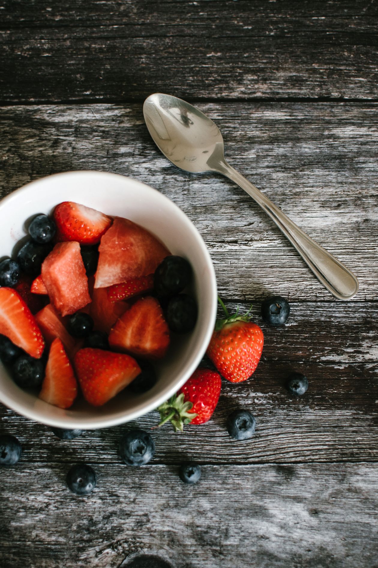 One Extra Serve of Fruit a Day Linked to Teen Health Gains A bowl of fresh strawberries and blueberries on a rustic wooden table
